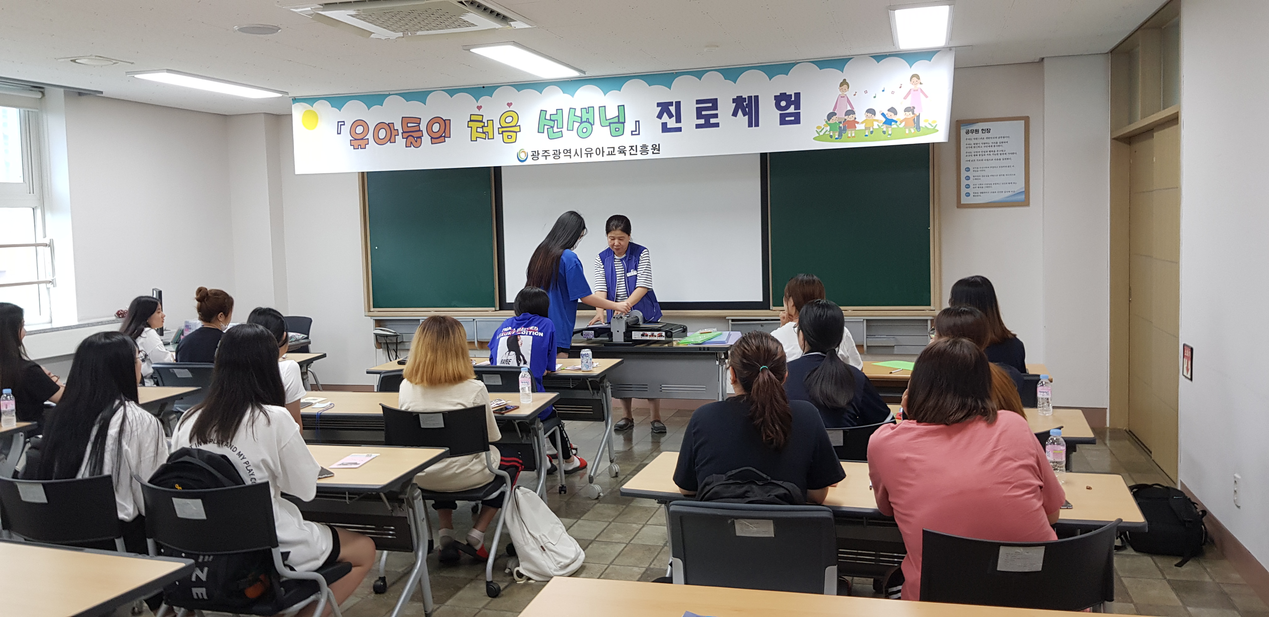유아들의 처음 선생님 진로체험 광주광역시유아교육진흥원 앞으로 나와 점검하고 받는 강사와 고등학생과 그걸 지켜보는 고등학생들