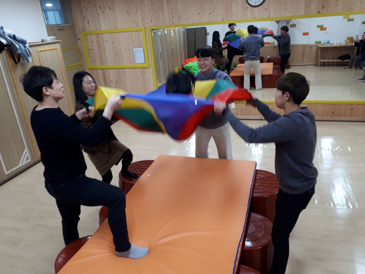 보자기 위에 아이를 두고 보자기를 잡고있는 부모들
