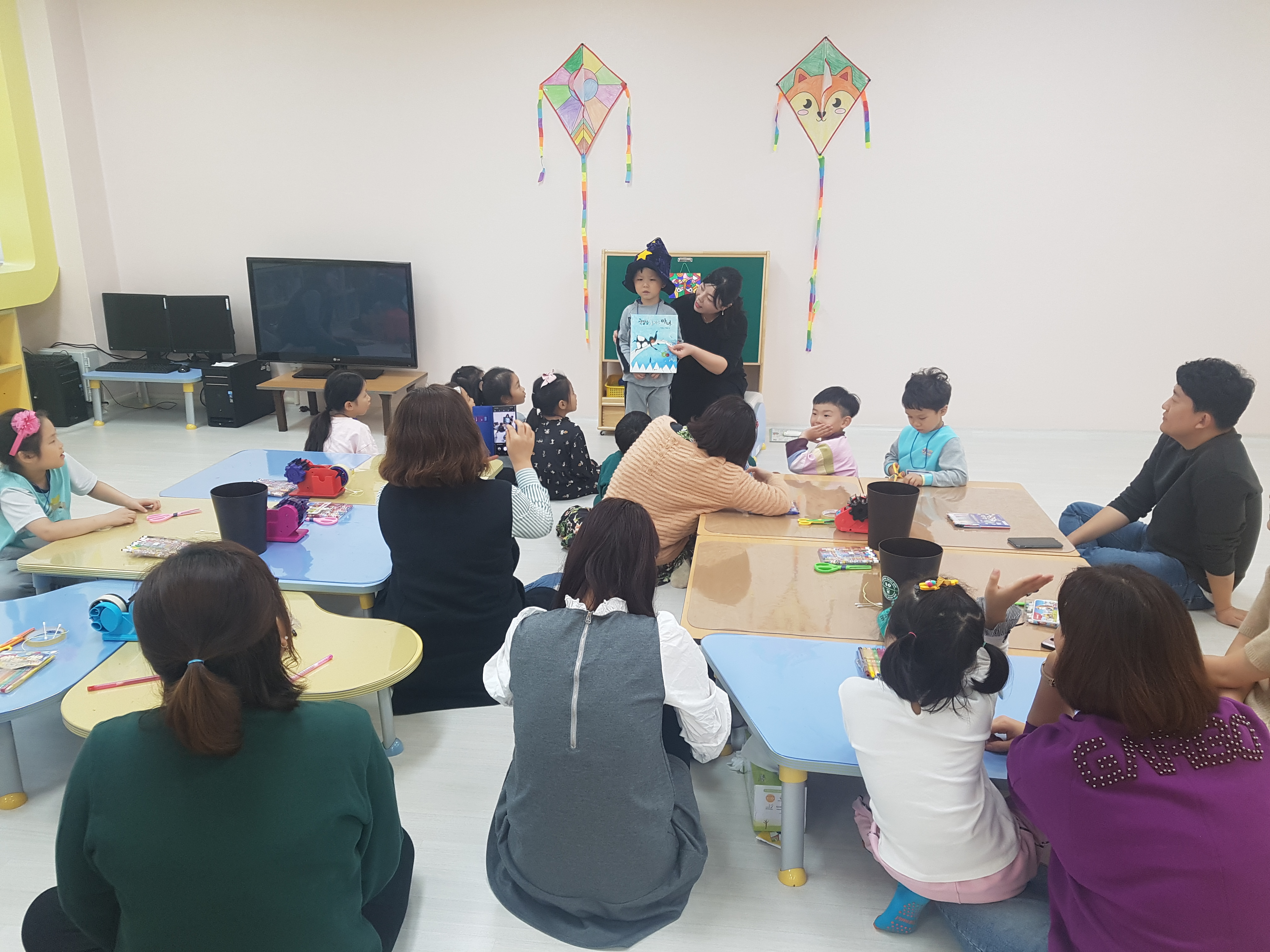 아이 한명이 대표로 나와 선생님과 동화책 내용을 함께 설명하고 그걸 지켜보는 부모와 유아들