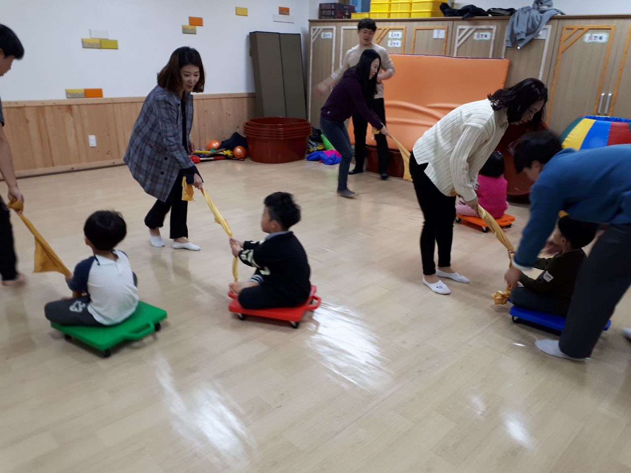 썰매에 타고있는 아이를 끌고 있는 부모들